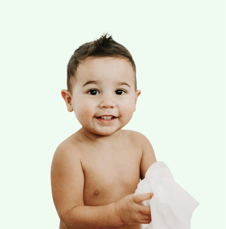 Baby holding a white wipe against a white background