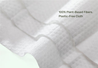 Close-up of wipe with text '100% Plant-Based Fibers, Plastic-Free Cloth' on a white background
